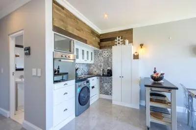 a kitchen with a washer and dryer in a room at Apartment18Lifestyle Gordons Bay Beachfront in Gordonʼs Bay