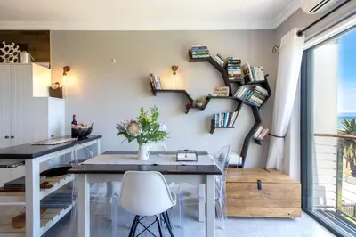 a kitchen and dining room with a table and chairs at Apartment18Lifestyle Gordons Bay Beachfront in Gordonʼs Bay