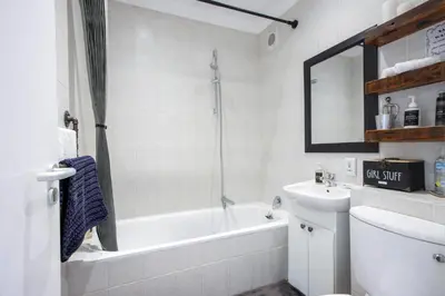 a bathroom with a tub and a toilet and a sink at Apartment18Lifestyle Gordons Bay Beachfront in Gordonʼs Bay