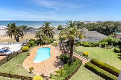 an aerial view of a resort with a swimming pool at Apartment18Lifestyle Gordons Bay Beachfront in Gordonʼs Bay