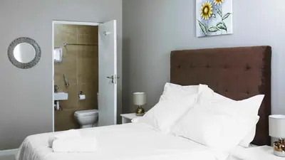 a bedroom with a bed and a bathroom with a toilet at 103onWallace Self Catering Guest House in Cape Town