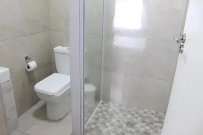 a bathroom with a toilet and a shower at 103onWallace Self Catering Guest House in Cape Town