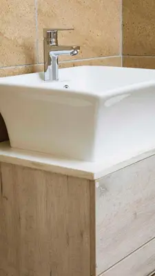 a white sink sitting on top of a wooden cabinet at 103onWallace Self Catering Guest House in Cape Town