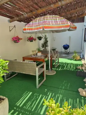 a patio with a table and an umbrella at Barlinka lane Selfcatering flatlet , Somerset West in Cape Town