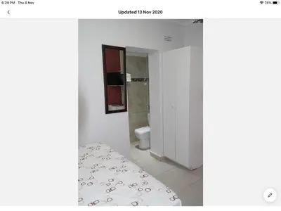 a bathroom with a bed and a toilet in a room at Tia Maria House in Cape Town