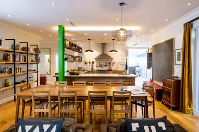 a kitchen and dining room with a wooden table and chairs at Luxury Apartments - Rozenhof Villa in Stellenbosch