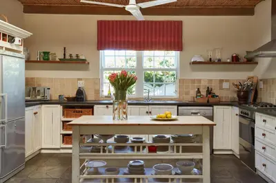 a kitchen with a island with a vase of flowers at Tockie's Cottage in Franschhoek
