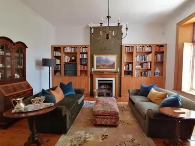 a living room with two couches and a fireplace at Avontuur Manor House and Wine Estate in Somerset West