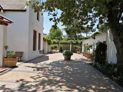 a courtyard of a white building with potted plants at Avontuur Manor House and Wine Estate in Somerset West