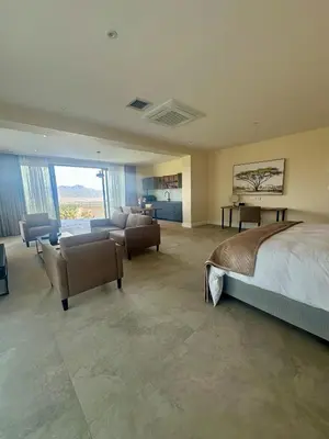 a large bedroom with a bed and a living room at Cape Vermeer in Somerset West