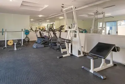 a gym with several treadmills and exercise machines at Hermanus Haven, entire home, on the sea, private pool, secure in Hermanus