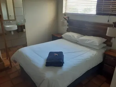 a bed with a blue bag sitting on top of it at Upstairs in Cape Town