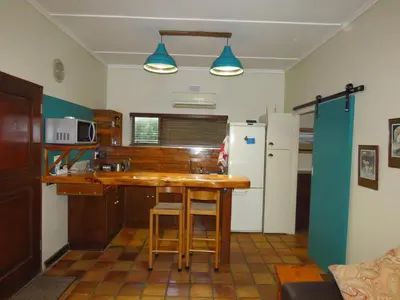 a kitchen with a sink and a refrigerator at Upstairs in Cape Town