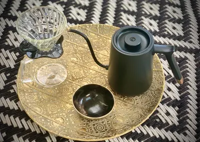 a gold table topped with a black tea pot and a cup at The Guardian Hermanus Luxury Self-Catering Hemel en Aarde Valley in Hermanus