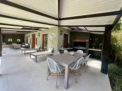 a patio with a table and chairs on it at The Guardian Hermanus Luxury Self-Catering Hemel en Aarde Valley in Hermanus