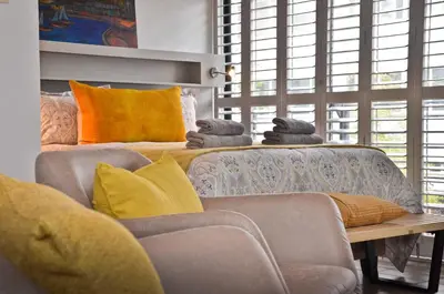 a living room with a couch and a table with pillows at Concord Modern Apartment in Stellenbosch in Stellenbosch