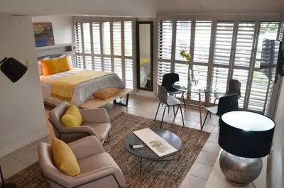 a bedroom with a bed and a table and chairs at Concord Modern Apartment in Stellenbosch in Stellenbosch