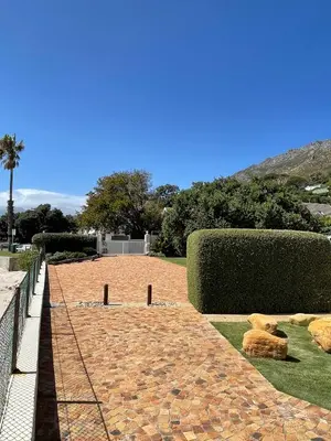 a brick walkway with teddy bears on the grass at By Die See in Gordonʼs Bay