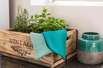 a wooden box with a green napkin next to a plant at Sunset Beach Living Guesthouse in Cape Town