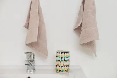 a bathroom counter with a sink and towels at Sunset Beach Living Guesthouse in Cape Town
