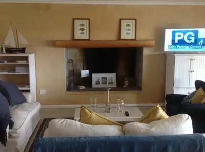a living room with a couch and a table at Sea front Rocky Pools in Bettyʼs Bay