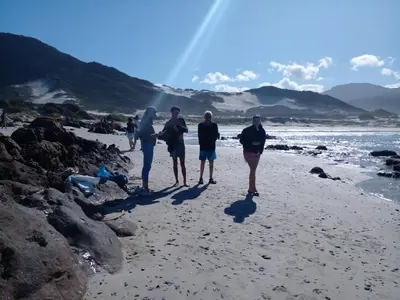a group of people walking on the beach at Sea front Rocky Pools in Bettyʼs Bay