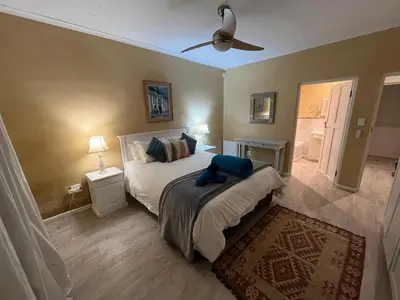a bedroom with a bed and a ceiling fan at Sea front Rocky Pools in Bettyʼs Bay