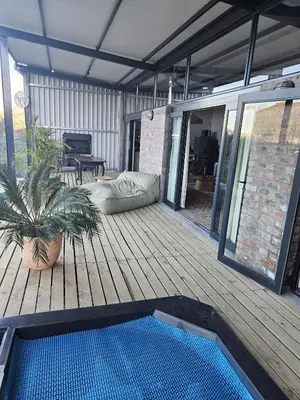 a deck with a swimming pool on a house at River Edge in Romansrivier