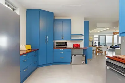 a kitchen with blue cabinets and a dining room at Blueview on Silversand in Clareport