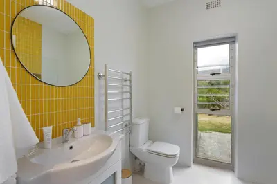 a bathroom with a sink and a mirror and a toilet at Blueview on Silversand in Clareport