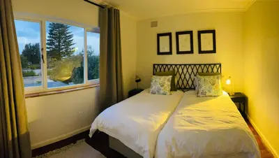 a bedroom with a large bed with a window at Villa Voigt in Hermanus