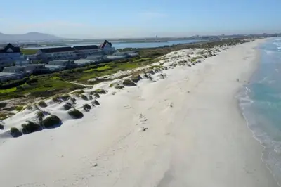 an aerial view of the beach in front of a resort at Dolphin Beach Villa E24 direct access to the beach in Cape Town