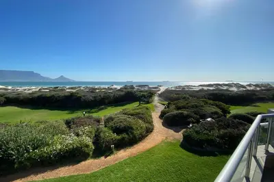 an aerial view of a golf course near the ocean at Dolphin Beach Villa E24 direct access to the beach in Cape Town