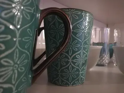 a green and white mug sitting on a table at Bachelor cottage STRICTLY HALAAL Garlandale Rondebosch East in Cape Town
