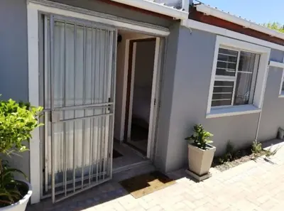 an open door of a house with plants in front at Bachelor cottage STRICTLY HALAAL Garlandale Rondebosch East in Cape Town