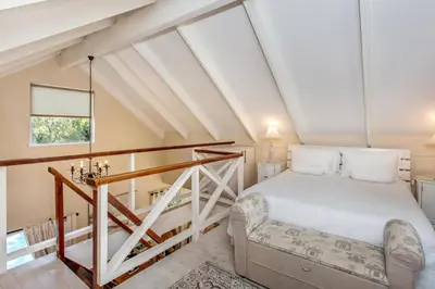 a attic bedroom with a bed and a window at Invergara in Cape Town