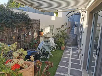 a patio with two chairs and a table and some plants at Protea Suite in Bellville