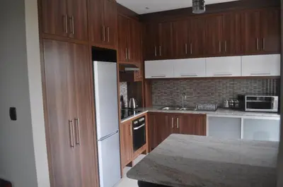 a kitchen with wooden cabinets and a white refrigerator at A Perfect Self Catering in Wellington