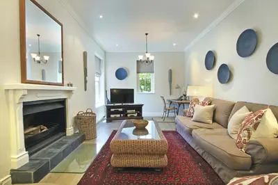 a living room with a couch and a fireplace at Le Bas De Laine in Franschhoek