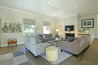 a living room with two couches and a tv at Le Bas De Laine in Franschhoek