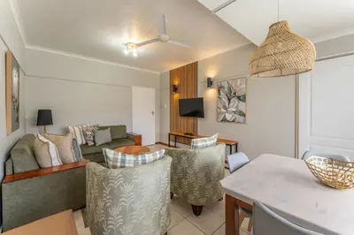 a living room with a couch and a table at Fairway Holiday Accommodation in Hermanus
