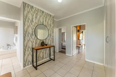 a bathroom with a mirror and a sink and a tub at Fairway Holiday Accommodation in Hermanus