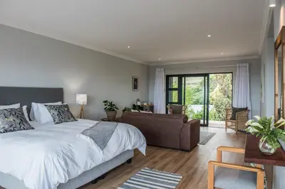 a bedroom with a large bed and a couch at Ridge House in Hermanus