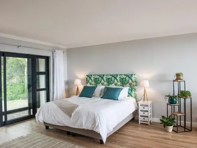a bedroom with a large white bed with blue pillows at Ridge House in Hermanus