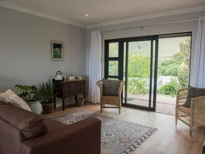 a living room with a couch and a sliding glass door at Ridge House in Hermanus
