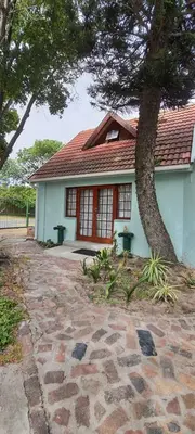 a house with a tree in front of it at Cozy Cottage +/- 500m from the beach in Cape Town