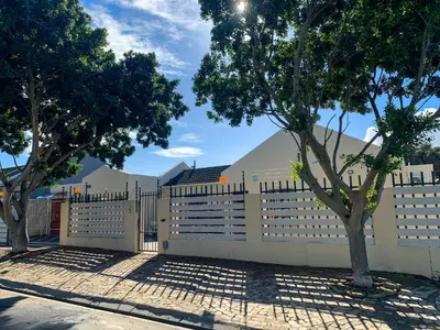 a white fence with trees in front of it at ALIAHIDI in Cape Town