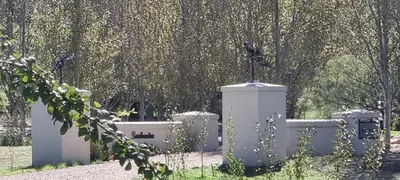 a cemetery with a fence and trees in the background at Sandmartins Private Secure Villa in Simondium