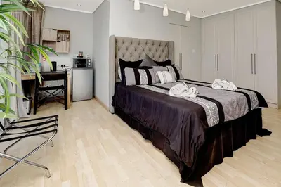 a bedroom with a large bed and a desk in it at The Model House in Cape Town