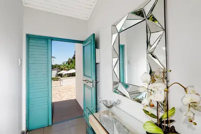 a bathroom with a blue door and a mirror at The Model House in Cape Town